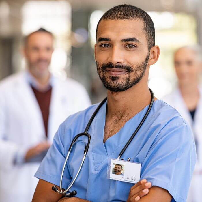 A male nurse with doctors in the background